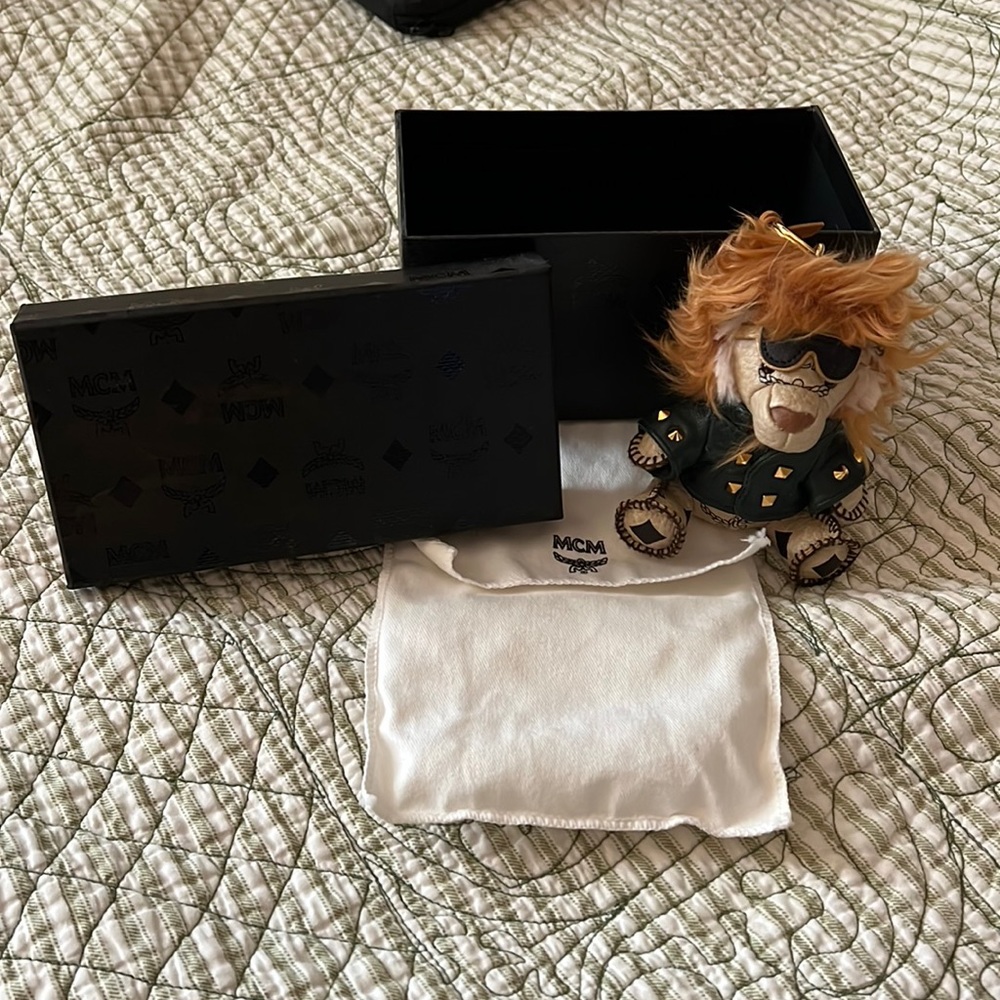 MCM bag charm lion in studded leather jacket